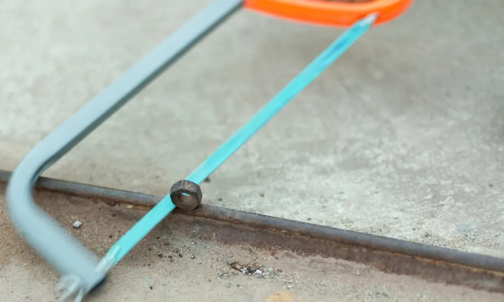 Cutting a nut with a hacksaw