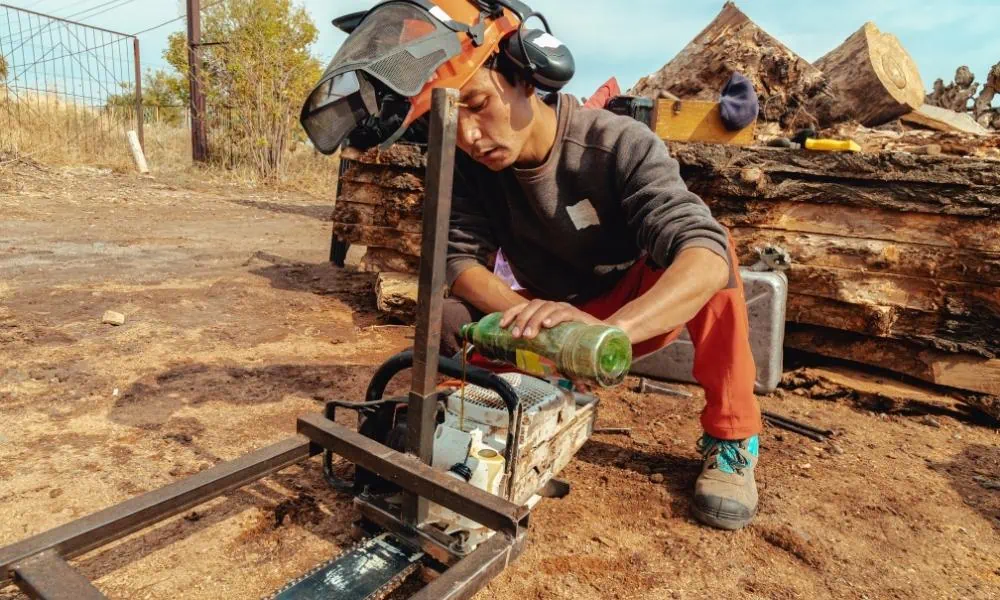 Lumber jack adding oil to chainsaw